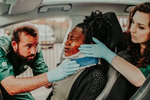 emergency workers treating the neck injury of a person involved in a car and large truck accident