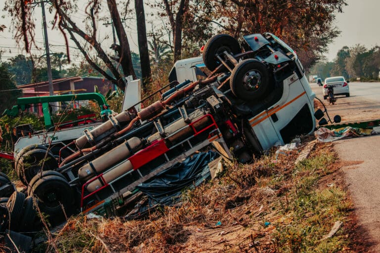 rollover trucking accident - truck lies on the side of the road after a large truck accident